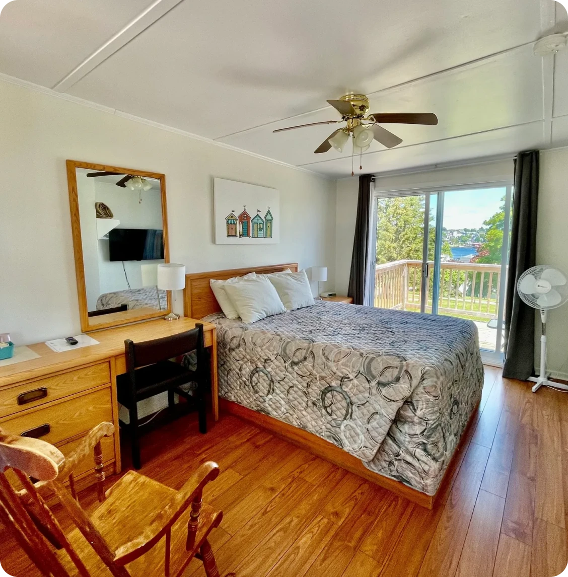 Cozy bedroom with window view and fan.